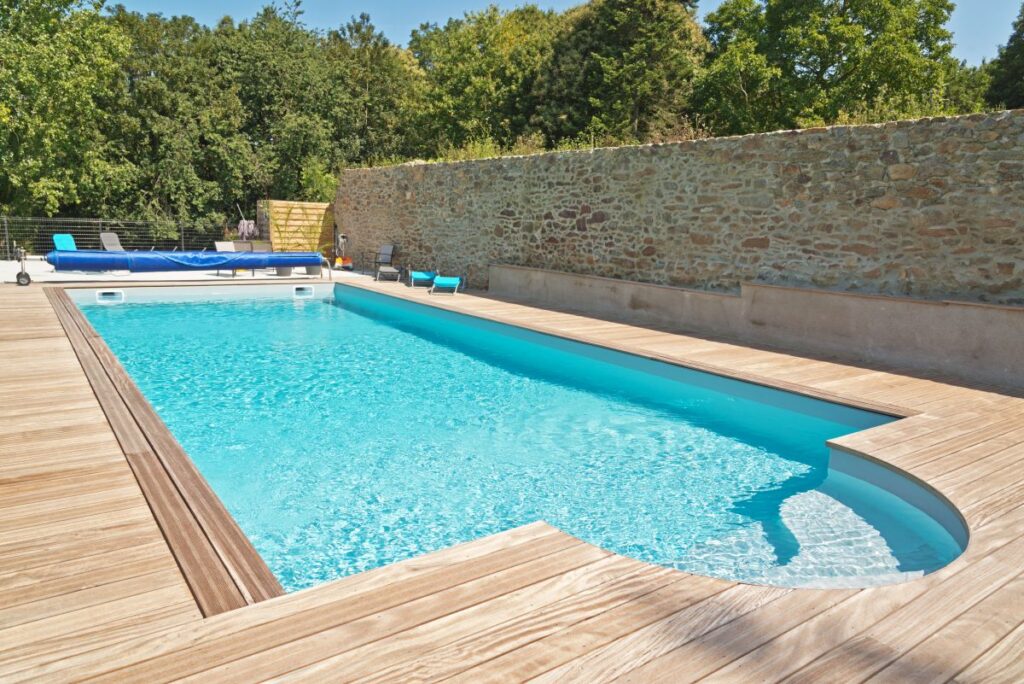 Summer outdoor swimming pool with green trees